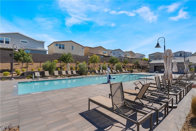 pool featuring a residential view, a patio area, and fence