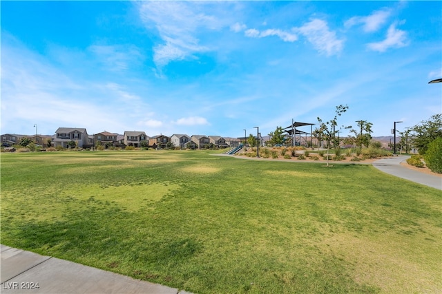 view of property's community featuring a residential view, playground community, and a lawn