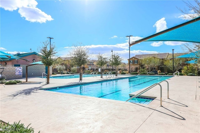 community pool featuring a patio and fence