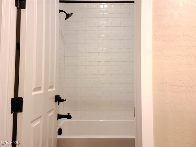 bathroom featuring tiled shower / bath