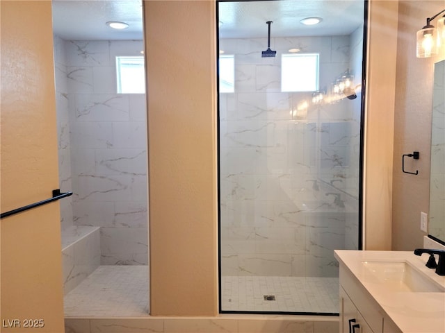 bathroom featuring a tile shower and vanity