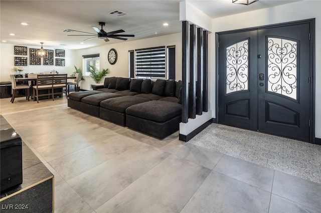 foyer with french doors and ceiling fan with notable chandelier