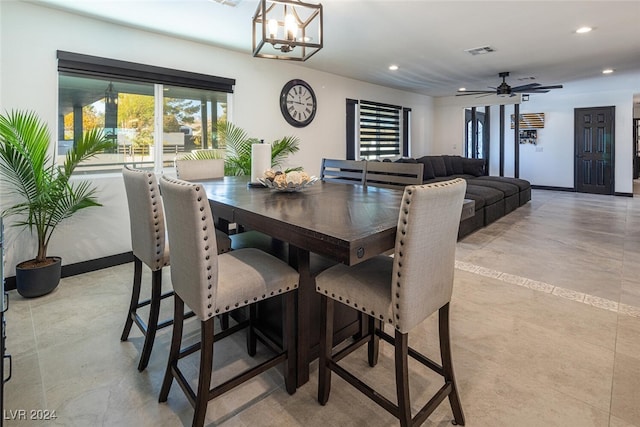 dining room featuring ceiling fan with notable chandelier