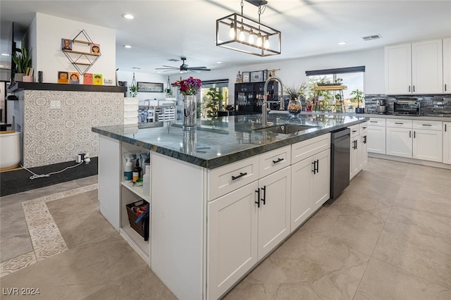 kitchen featuring ceiling fan, sink, a center island with sink, black dishwasher, and white cabinetry