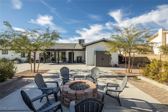 view of patio with central AC and a fire pit