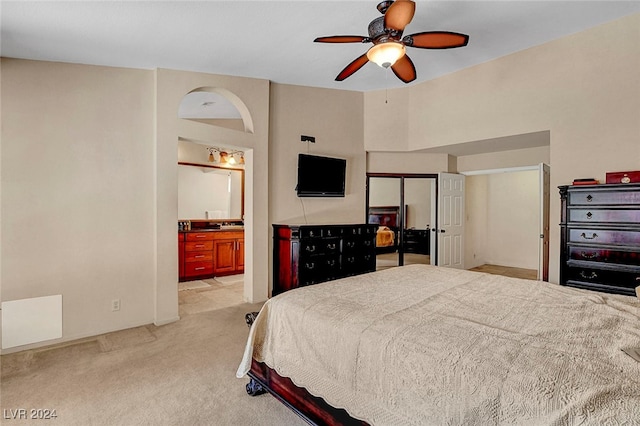 carpeted bedroom with ceiling fan and ensuite bathroom