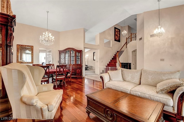 living room featuring hardwood / wood-style flooring, a chandelier, and high vaulted ceiling