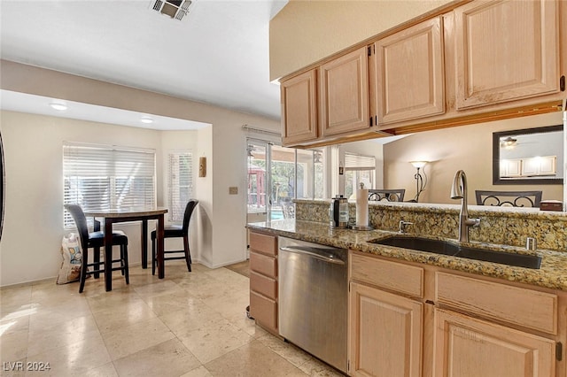 kitchen with light brown cabinetry, stainless steel dishwasher, light stone countertops, and sink