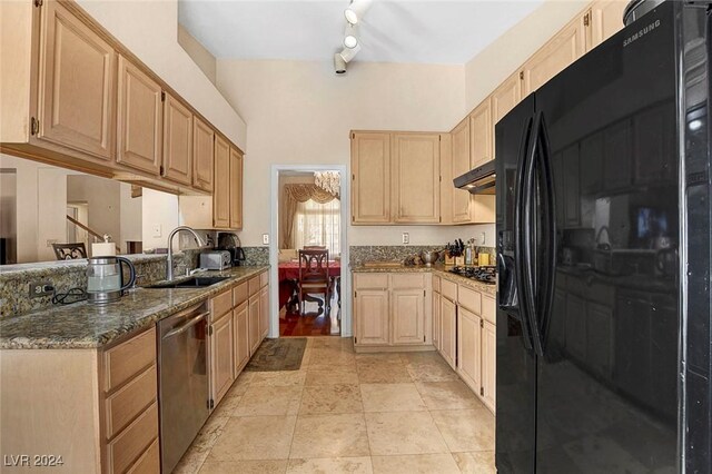 kitchen featuring dark stone counters, stainless steel appliances, light brown cabinets, and sink