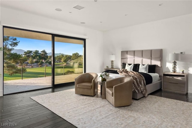 bedroom featuring access to outside, wood finished floors, and visible vents