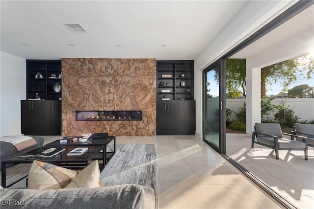 living room featuring visible vents, a high end fireplace, and built in features