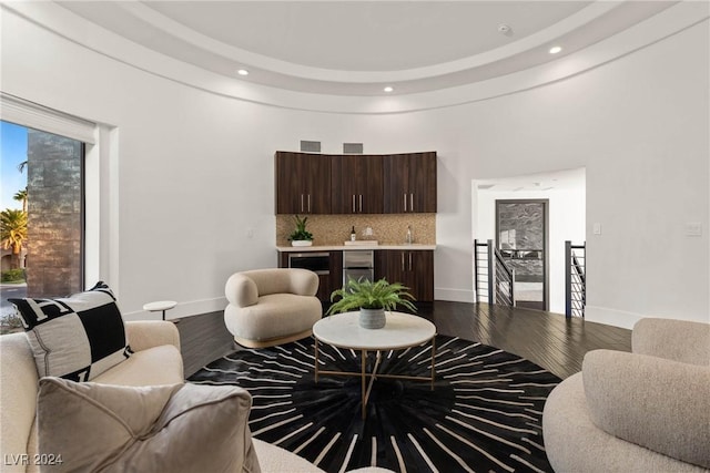 living area featuring recessed lighting, wood finished floors, visible vents, baseboards, and indoor wet bar