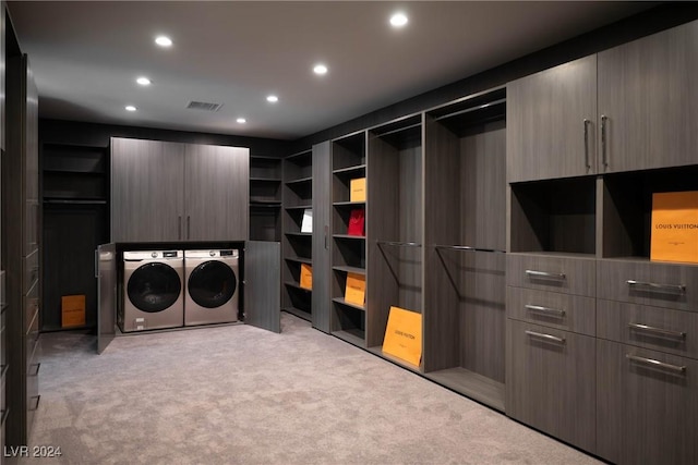 walk in closet with carpet floors, washing machine and dryer, and visible vents