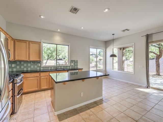 kitchen featuring sink, backsplash, decorative light fixtures, light tile patterned floors, and appliances with stainless steel finishes