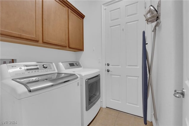 clothes washing area with light tile patterned floors, cabinet space, and independent washer and dryer