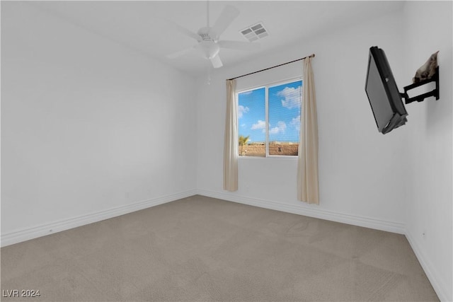 carpeted empty room with baseboards, visible vents, and ceiling fan