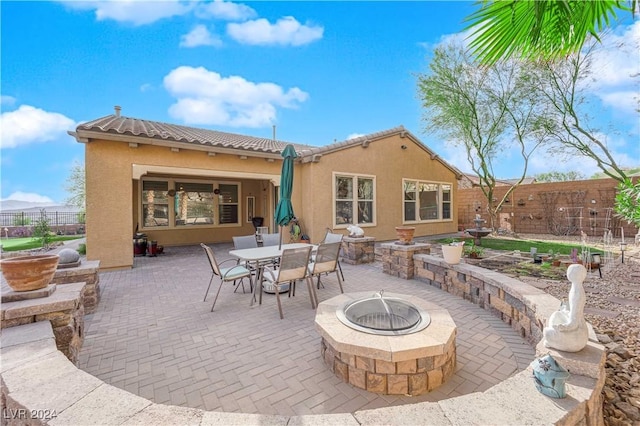 view of patio featuring a fire pit, outdoor dining area, and fence