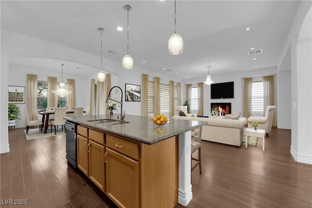 kitchen with dishwasher, dark wood-type flooring, stone countertops, and visible vents
