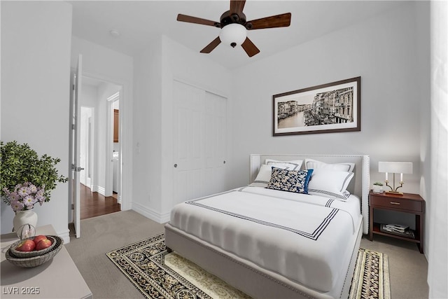 carpeted bedroom featuring a closet, baseboards, and ceiling fan