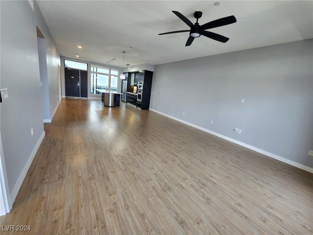 unfurnished living room with light hardwood / wood-style floors and ceiling fan