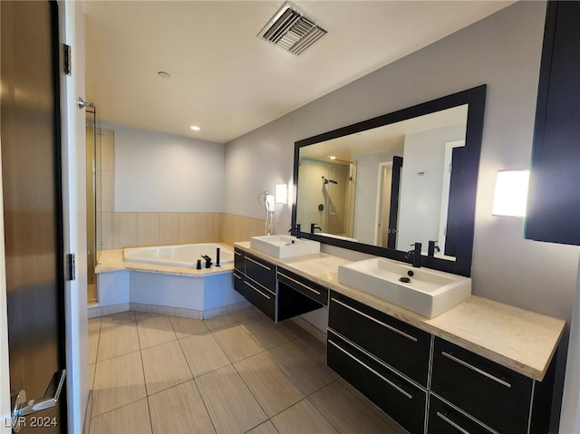 bathroom featuring independent shower and bath, vanity, and tile patterned floors