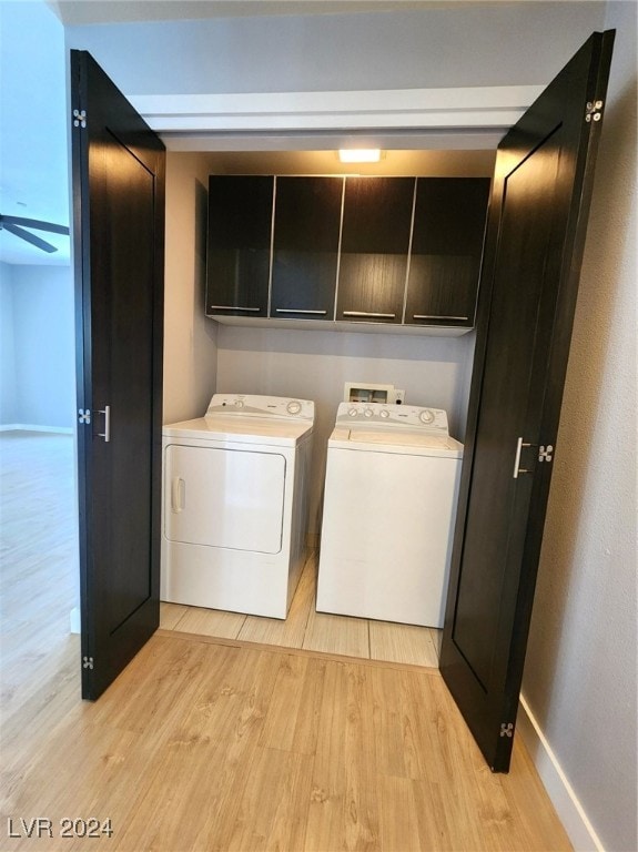 laundry room with cabinets, light hardwood / wood-style floors, and independent washer and dryer