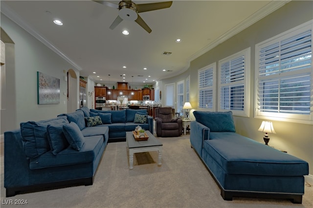 carpeted living room featuring ornamental molding and ceiling fan