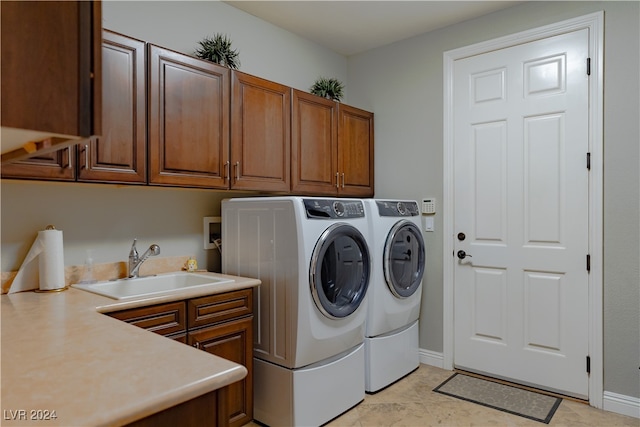 laundry room with washer and clothes dryer, sink, light tile patterned floors, and cabinets