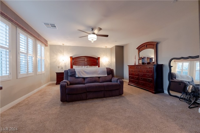 carpeted bedroom featuring ceiling fan and multiple windows