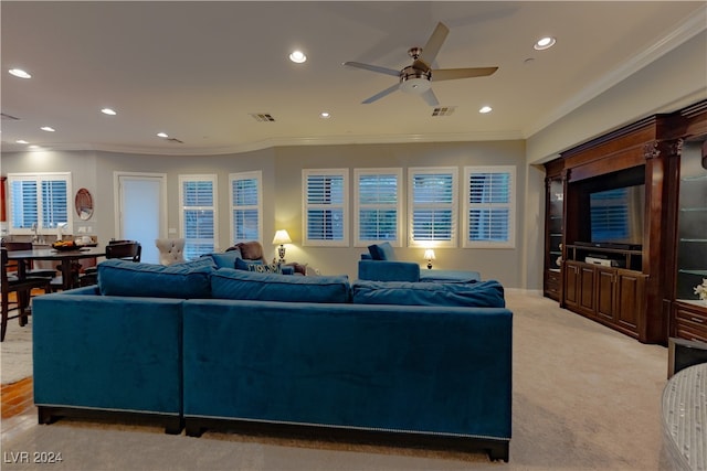 carpeted living room with ceiling fan, ornamental molding, and a wealth of natural light