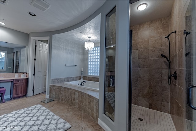 bathroom featuring vanity, plus walk in shower, tile patterned flooring, and a wealth of natural light