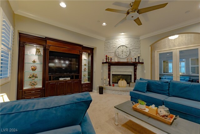 carpeted living room featuring ornamental molding, ceiling fan, and a fireplace