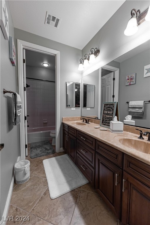 full bathroom with tiled shower / bath combo, vanity, and toilet