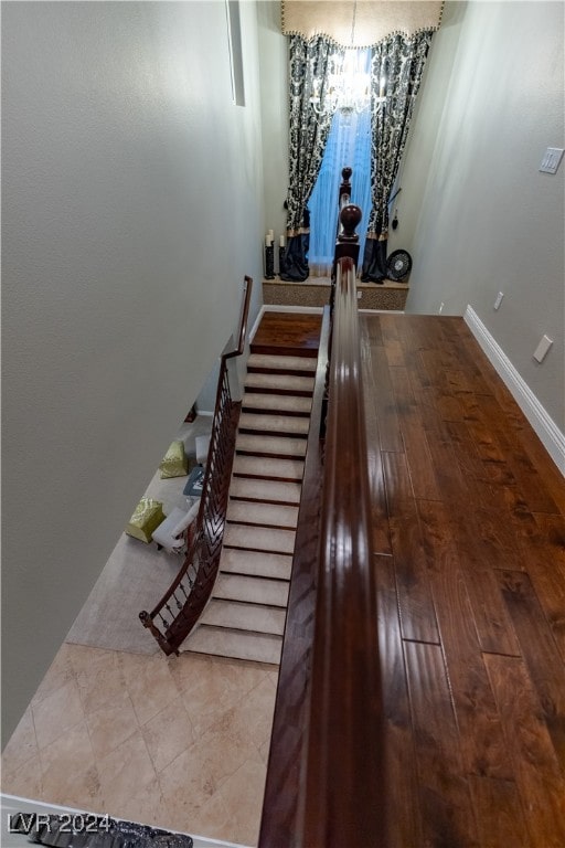 staircase featuring hardwood / wood-style floors and a chandelier