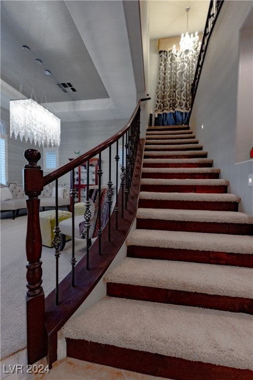 stairway featuring a notable chandelier