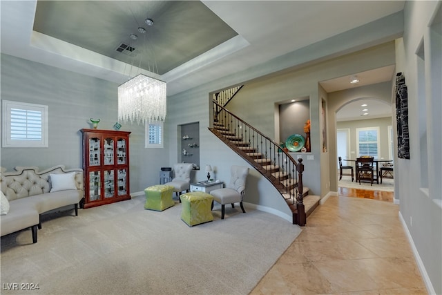 interior space featuring an inviting chandelier and a raised ceiling