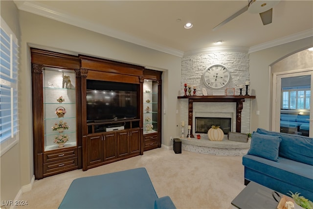 carpeted living room featuring a fireplace, ornamental molding, and ceiling fan