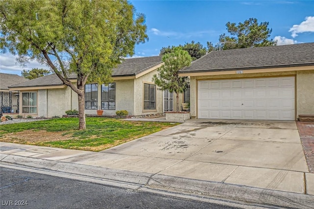 view of front of property with stucco siding, concrete driveway, a garage, and a front yard