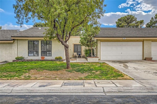 view of front of home with stucco siding, a garage, and driveway