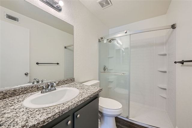 bathroom with wood-type flooring, vanity, toilet, and an enclosed shower