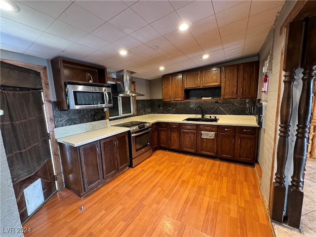 kitchen featuring light wood-type flooring, sink, stainless steel appliances, backsplash, and exhaust hood