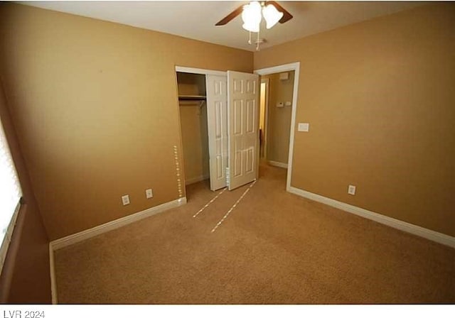 unfurnished bedroom featuring ceiling fan, a closet, and light colored carpet