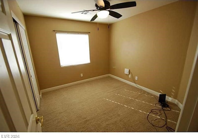 carpeted spare room with ceiling fan