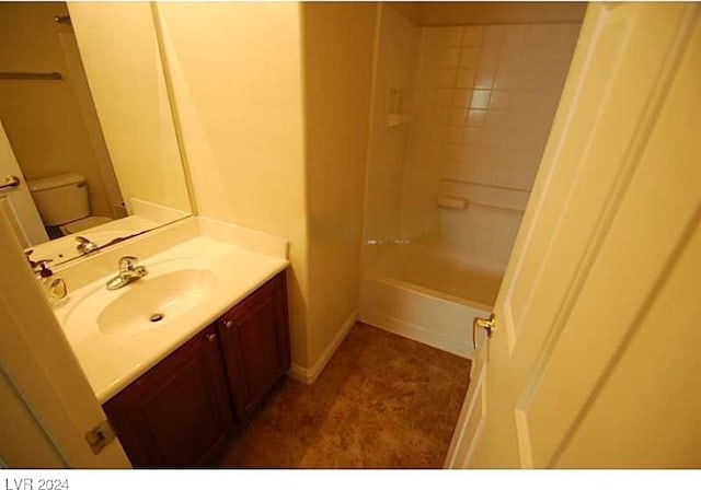 full bathroom featuring tiled shower / bath, vanity, and toilet