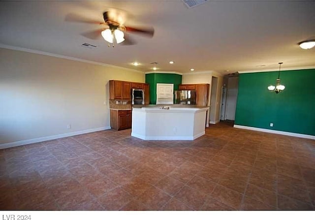 kitchen featuring hanging light fixtures, a kitchen island, fridge, and crown molding