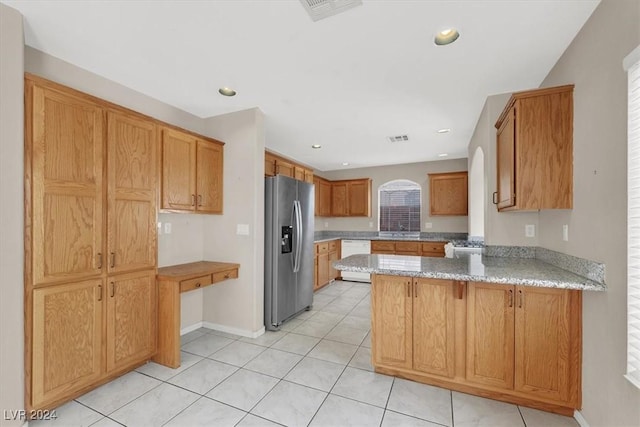 kitchen featuring a peninsula, stainless steel fridge, dishwasher, and visible vents