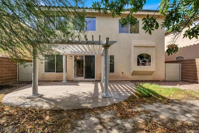 rear view of property with stucco siding, a pergola, fence, and a patio area