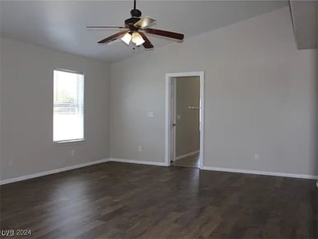 spare room featuring ceiling fan, dark wood-type flooring, and vaulted ceiling