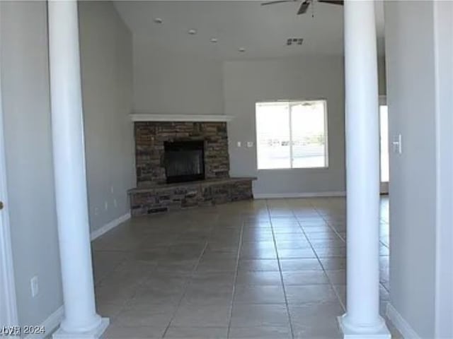 unfurnished living room with a fireplace, ceiling fan, and tile patterned floors