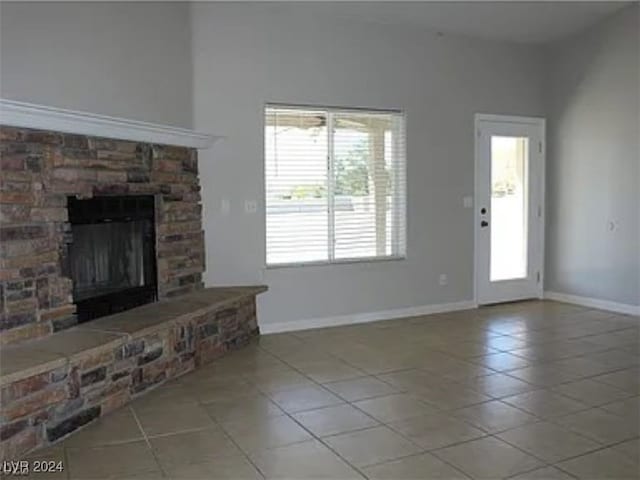 unfurnished living room featuring a fireplace and light tile patterned floors